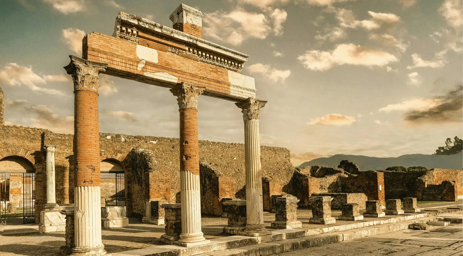 A monumental arched gateway among the ruins of Pompeii, one of the city's grand entrances