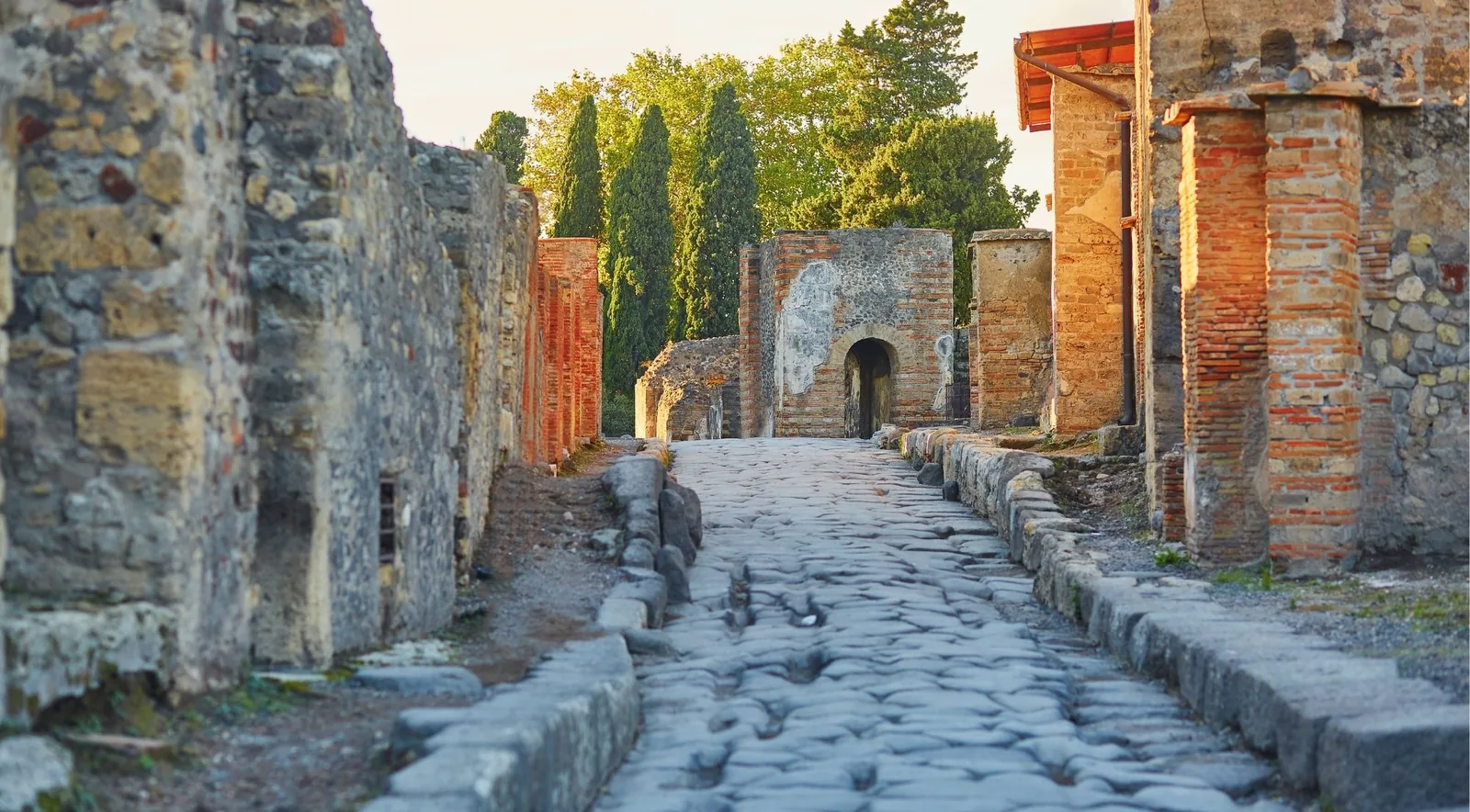 An ancient basalt-paved street in Pompeii, worn uneven by centuries of cart traffic